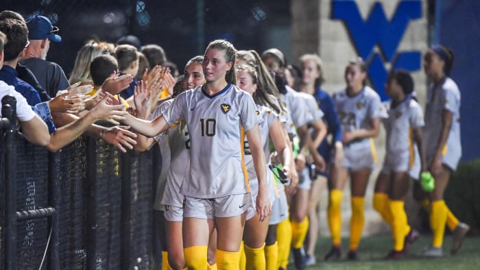 WVU defender Jordan Brewster shakes hands with fans post-game.
